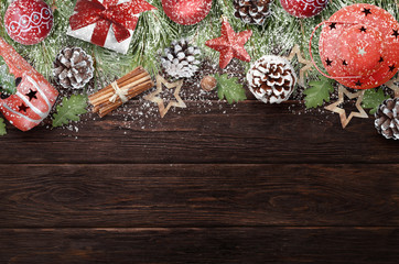 Christmas decorations on dark wooden table covered with snowflakes. Christmas background
