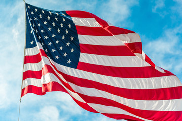 American flag waving in blue cloudy sky