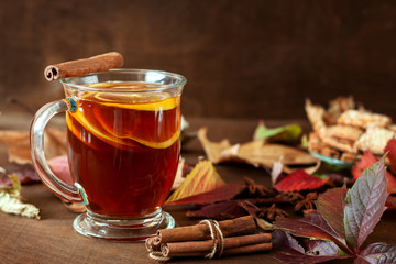 A cup of hot tea on the background of autumn foliage