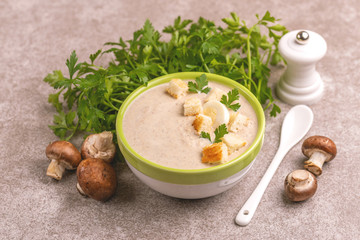 Tasty pureed mushroom soup in clay bowl with ingredients