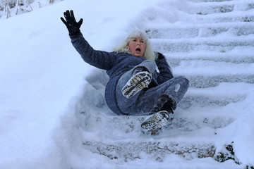 Eine Frau ist auf einer schneeglatten Treppe ausgerutscht und hingefallen