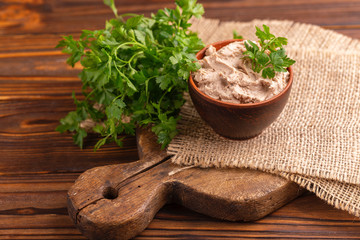 Obraz na płótnie Canvas Homemade chicken liver pate with parsley in clay bowl