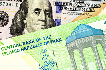 An American one hundred dollar bill in macro with an Iranian ten thousand rial note