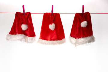 trois chapeaux de père noël suspendu à un fil