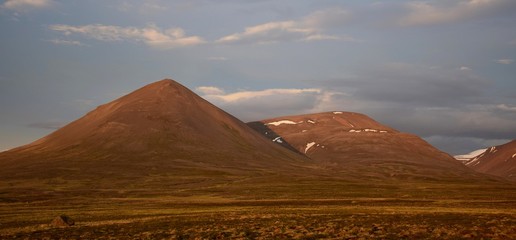 A midsummer night in Iceland. A mountain is glowing in the midnight sun. The Svinadalsfjall near...