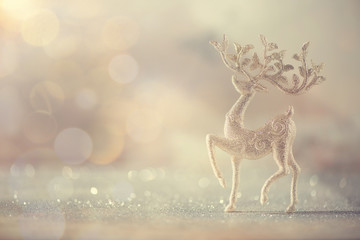 Silver glitter Christmas deer on grey background with lights bokeh, copy space. Greeting card for...