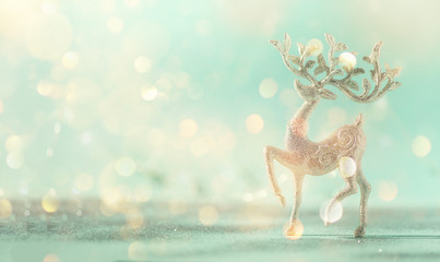 Silver glitter Christmas deer on blue background with lights bokeh, copy space. Greeting card for new year party. Festive holiday concept. Banner