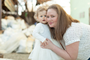 Mother with her little curly daughter playing on the background