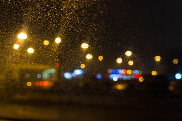 City lights behind glass with raindrops