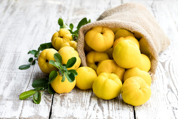 Fresh quince fruits on white wooden table