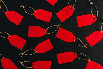 Black Friday sales discount composition. Red tags on black background. Flat lay, top view.