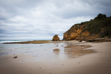 Fototapeta na wymiar Cliff and rocky beach on a beautiful cloudy day in the middle of Great Ocean Road, Victoria, South Australia.