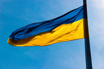 flag of ukraine waving in the wind in front of blue sky