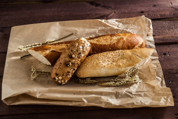 mix of different varieties of bread lying on a wooden table