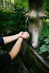 Woman's Hand in Front of Fountain Standing in the Woods