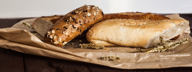 mix of different varieties of bread lying on a wooden table