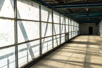 Modern overhead passage from steel and glass, perspective, long tunnel in sunset light