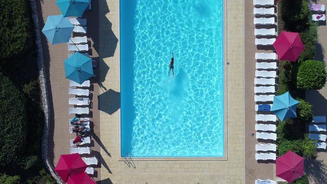 Man in a swimming pool luxury hotel aerial drone view