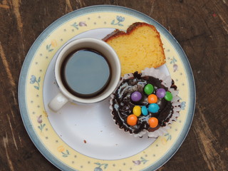 Xícara com café e bolinho cobertura chocolate