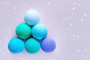 Toys to decorate the Christmas tree in the form of colored balls of thread laid out in the shape of a pyramid resembling a Christmas tree. Snowflake effect applied