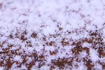 Fototapeta na wymiar White snow on a wooden board. Close-up. Background. Texture.