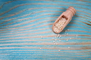 spoon with sesame seeds on blue wooden table. macro copy space