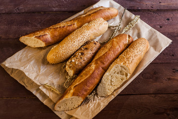 mix of sorts of baguettes on a wooden table. Bakery products.
