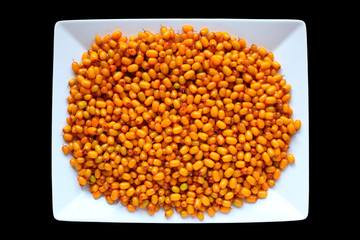 Ripe sea buckthorn berries on a white plate. Close-up. Isolated object on a black background. Isolate.