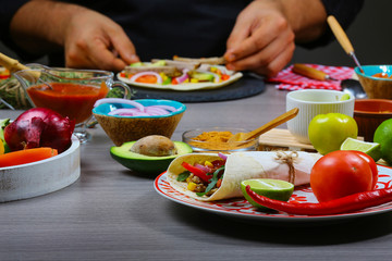 male street vendor hands making taco. Mexican cuisine snacks, cooking fast food for commercial kitchen