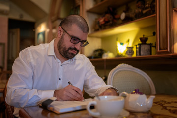 Male adult writing in a notebook