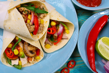 Taco - traditional dish of Mexican cuisine. Mexican tacos with beef, vegetables and sauce on a wooden background. Top view