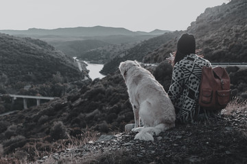 Young girl traveling by nature with backpack and dog