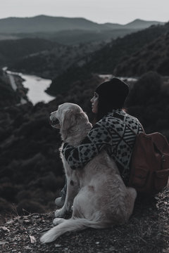 Young girl traveling by nature with backpack and dog