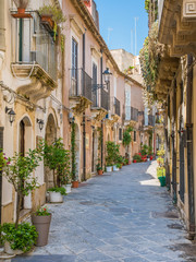 Fototapeta na wymiar A narrow and picturesque road in Ortigia, Siracusa old town, Sicily, southern Italy.