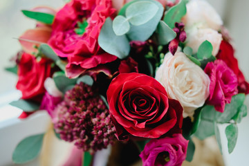 Wedding bouquet with red and white roses of different varieties in autumn colors. Close up flowers.