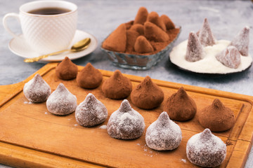 Chocolate truffles with white and brown powder on a wooden Board.