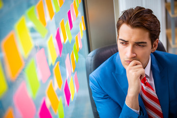 Young handsome employee with many conflicting priorities   