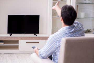Young man watching tv at home