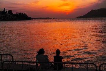 Young couple sitting on the beach near the sea