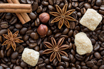 Coffee beans background, cinnamon rolls, anise, brown sugar and hazel nuts.