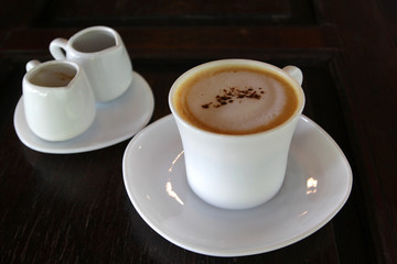 hot cappuccino coffee on wooden table