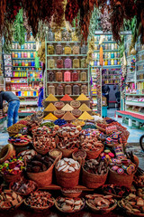 A colorful spice stall at night, with jars and piles of spices in Rahba Kedima Square in Marrakesh, Morocco