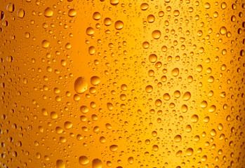 fresh cool beer in glass with droplets as textured background