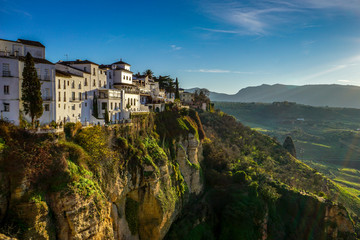 The Andalusian white city of Ronda is illuminated by the late afternoon sun as it overlooks the...