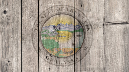 Fototapeta na wymiar USA Politics News Concept: US State Alaska Seal Wooden Fence Background