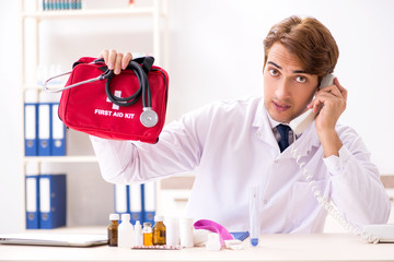 Young doctor with first aid kit in hospital