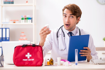 Young doctor with first aid kit in hospital