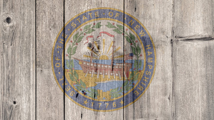 USA Politics News Concept: US State New Hampshire Seal Wooden Fence Background