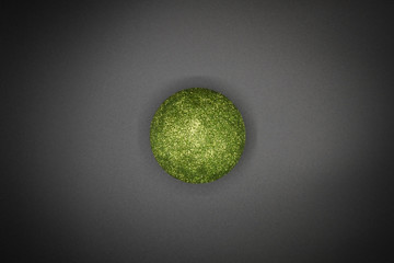 Green christmas bauble on black background. Centered.