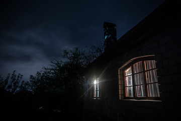 Mountain night landscape of building at forest at night with moon or vintage country house at night with clouds and stars. Summer night.